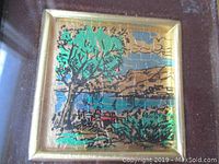Close-up of the 23 karat gold lithograph artwork featuring a tree and seaside scene with visible gold background and color detail.