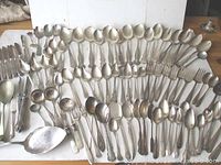 Full display of many silver plated spoons, forks, and serving utensils in various patterns