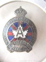 Close-up of enameled hat pin showing design, colors, and inscriptions