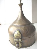 Full view of the antique Persian lock box showing conical tapering lid with finial and round body.