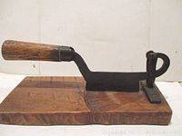 Full side profile showing blade mounted on wooden base with handle