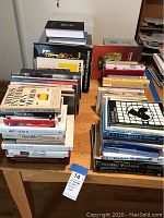 Image showing stacks of books on a table, titles covering various topics including art, philosophy, religion, philosophy, and literature.