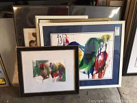 Group view of five framed artworks stacked upright