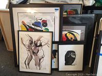 Five framed artworks clustered against shelving