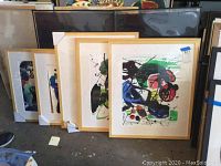 Five framed abstract artworks by Jenik Cook leaning against a wall