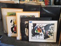 Overview of all five framed abstract artworks in black and light wood frames
