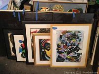 Five framed abstract artworks leaning against wall