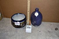 Overall view of pot and vase side by side with upright ruler and lot tag