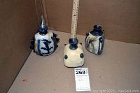 Three vases arranged next to a wooden yardstick showing overall size