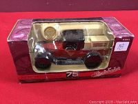 Original unopened packaging showing front of red and black diecast Studebaker pickup coin bank with Canadian Tire Corporation logo and packaging details.
