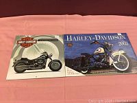 Two Harley-Davidson calendars placed side by side on a surface, showing front covers with shrink wrap intact.