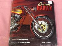 Front cover of The Custom Harley book showing close-up of a custom Harley Davidson motorcycle engine and wheel with sunset background.
