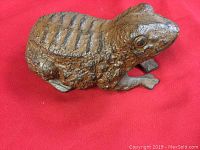 Side angle showing textured frog shape cast in iron with brown finish