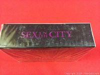 Top view of the black box with purple 'SEX IN THE CITY' text.