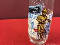 Close-up side view of the glass showing printed graphics of C3PO and R2D2 with background design and logo.