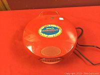 Closed view of the red Santa Fe Quesadilla Maker showing brand label on the top.