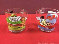 Both Garfield glass coffee mugs showing colorful cartoon scenes and quotes