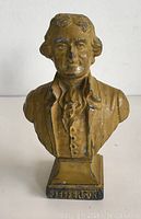 Front view of the vintage metal bust showing detailed facial features, clothing, and the inscription 'JEFFERSON' on the base.