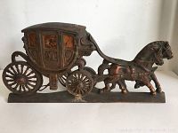 Full view of the vintage metal horse-drawn carriage figure showing carriage with two horses and overall antique patina.