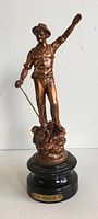 Front view of full 11-inch statue of miner with arm raised, standing on rocky base.