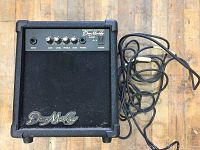 Front angle view of black Dean Markley K-15X amplifier with power cord, control knobs and Dean Markley logo.