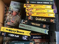 Close-up of various VHS movies showing titles like Objective Burma!, Casablanca, and The Dirty Dozen.