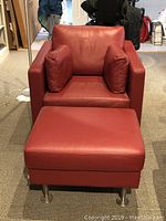 Front view of red leather armchair and matching ottoman with two cushions