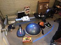 Wide view of LifeSpan rower rail, BOSU trainer box, Ektelon racket, scale, and Nerf gun box
