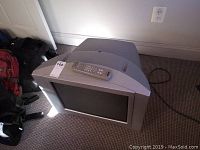 Sony CRT TV from angled front view with remote placed on top of the TV.