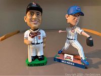 Front view of Cal Ripken Jr. and Greg Maddux bobbleheads showing uniforms and poses.