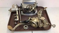 Front view of two vintage manual meat grinders and chrome-plated toaster on tray
