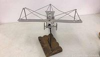 Side view of metal welded airplane sculpture on wooden base
