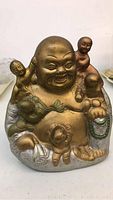 Front angle of the heavy bronze Buddha statue showing the laughing Buddha surrounded by child figurines
