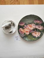 Photo shows Adderley white cup and saucer with brown floral design next to Royal Doulton round plate with painted lotus flowers