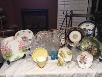Full lot overview showing plates, glasses, vase, and various porcelain items arranged on a white cloth.