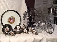 Full view of all items including the German Bavaria china set, silver-plated cake plate, cut glass bowls, Victorian claret decanter, and Italian cut glass trinket box