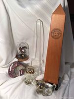 Wide shot showing the collection: Franklin Mint eagle dome, pink tourmaline stone, vintage obelisk, glass owl and cat figurines, and an additional pink stone.