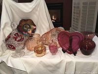 Full lot display of various signed and vintage glassware including bowls, powder box, cookie jar, and art glass pieces.