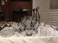 Full view of assorted glassware on white cloth including decanter, stemware, ice bucket, and bowls.