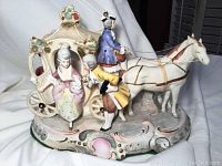 Angled view showing carriage, two horses, and figures with carriage details