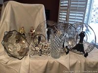 Photo of silver inlay servingware including footed bowl, vases, scalloped platters and a decorative glass bowl with etched silver pattern. Also shows the Capodimonte horse and carriage figurine.