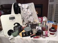 Overall view of lot showing skincare bottles, makeup, bathroom accessories, and a digital scale