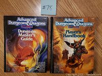 Both hardcover books side by side with covers visible, Dungeon Master's Guide on left with red dragon and Player's Handbook on right with armored rider figure.