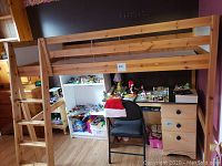 Frontal view of pine loft bed frame showing guard rails and integrated ladder next to shelving