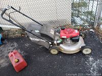 Full view of mower with grass bag and red engine housing, fabric grass collection bag attached