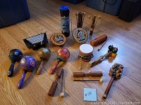 Wide view of the entire lot showing all twelve native musical instruments arranged on the floor.