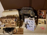Antique White Zig Zag sewing machine, Bernette serger machine, cases, and accessories with sewing supplies and threads.