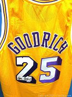 Photo showing the back of the yellow Lakers basketball jersey with Goodrich name and number 25 with black autograph on the number 2.