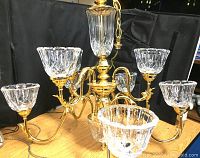 Angle showing the brass arms and large leaded crystal cups attached to each arm, highlighting the cup size and detailing.