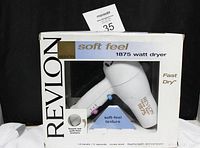 Front view of the Revlon Soft Feel 1875 watt hair dryer in original box with visible buttons and branding, showing the product clearly.